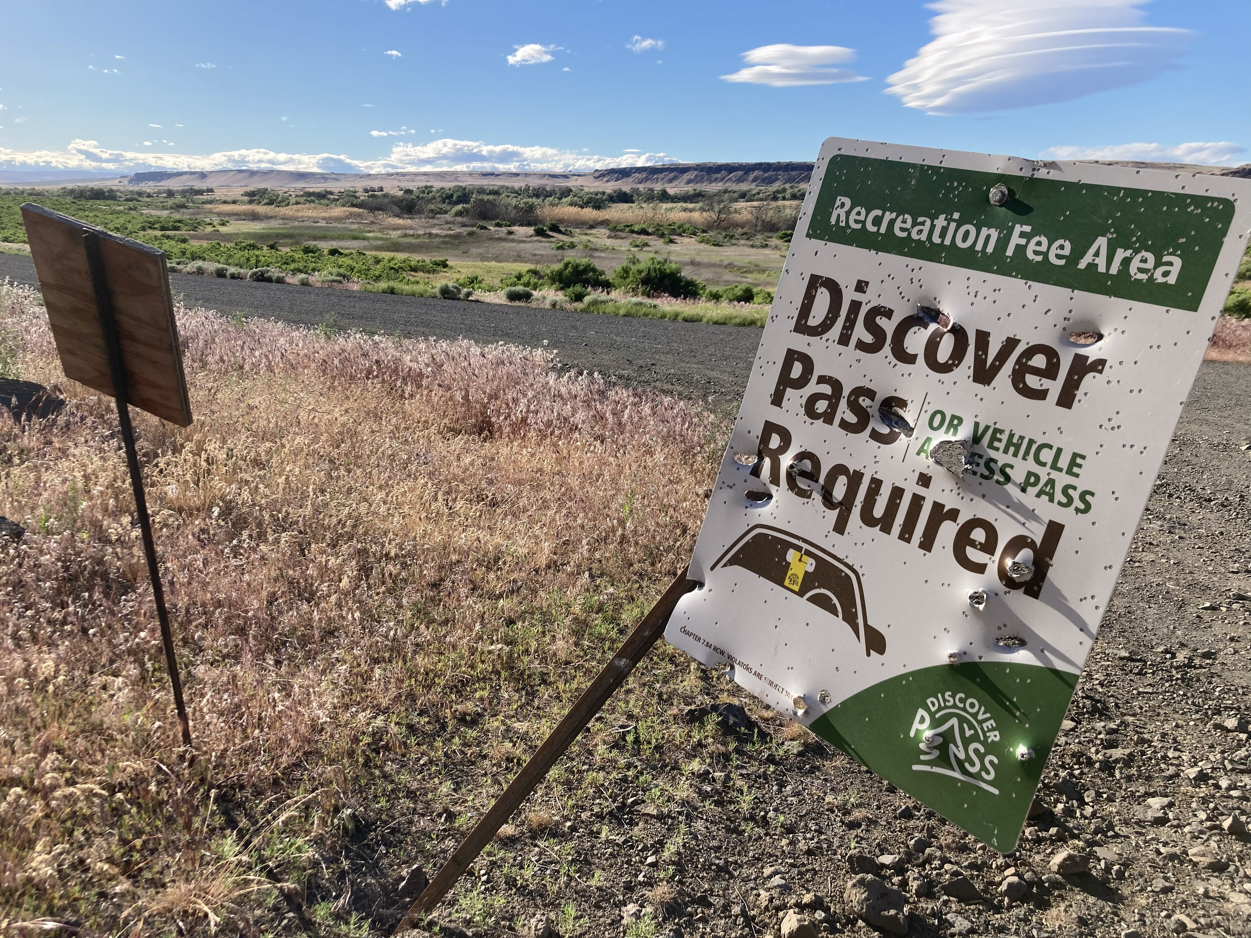 Discover Pass sign shot through with bulletholes